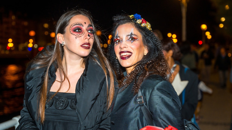 Two women are dressed up in Halloween costumes and are posing for a picture