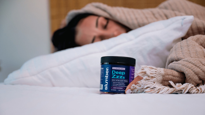 woman sleep next to Deep ZZZ gummies