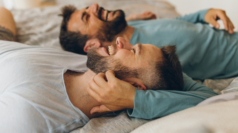 Happy couple laughing in bed