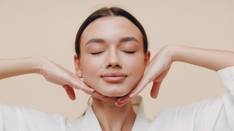 A woman performing face yoga