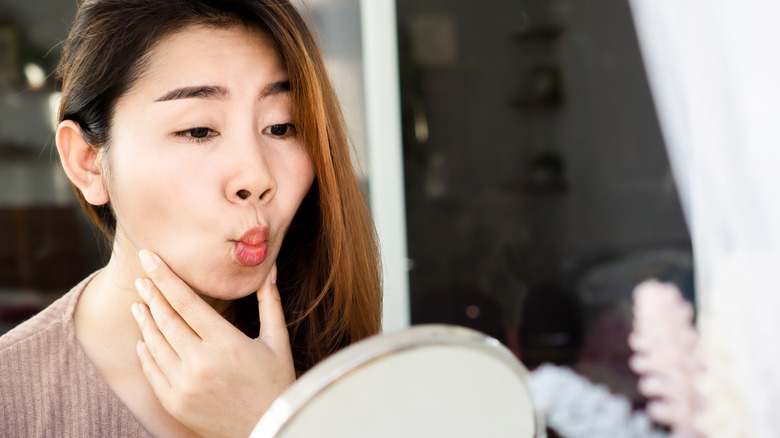 A woman performing face yoga