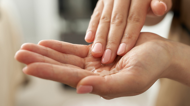 A woman using a skin care essence