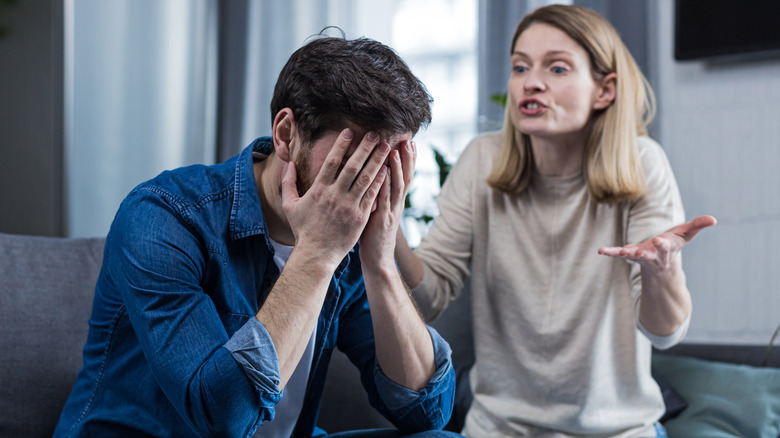 Fighting couple on couch, woman yelling at man