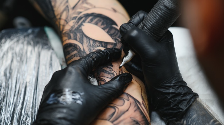 woman with tattoo sleeve sitting in chair