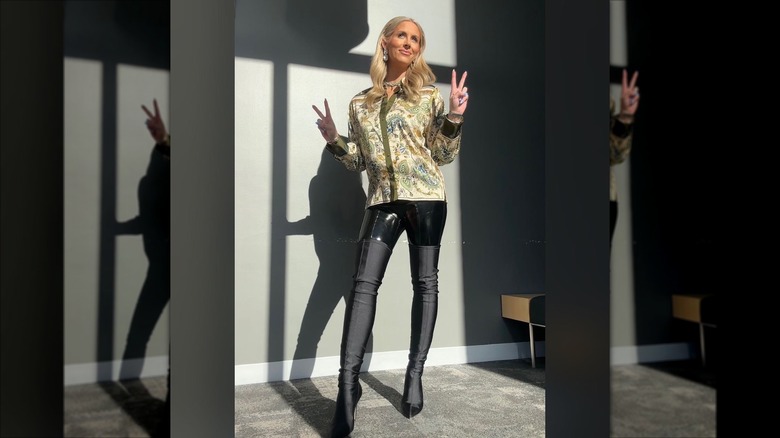 Laura Rutledge in a shirt, leggings and tall boots