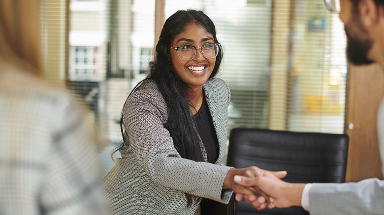 Woman shakes hands with an interviewer