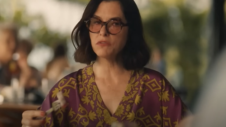 Parker Posey wearing sunglasses and eating