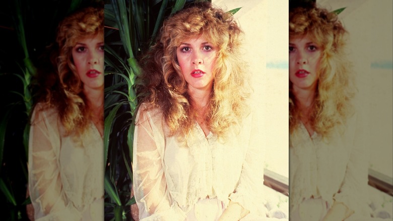 Stevie Nicks posing in a white outfit during a 1983 photoshoot