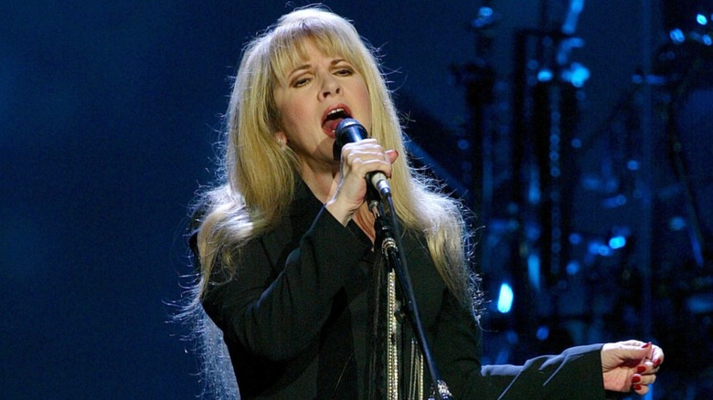 Stevie Nicks wearing all-black while performing on stage in 2006