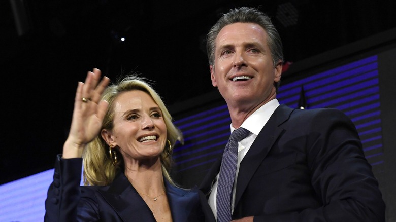 Jennifer Siebel Newsom waving next to Gavin Newsom