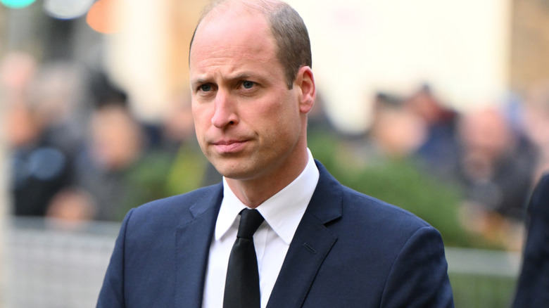Prince William looking stern wearing a suit at an event