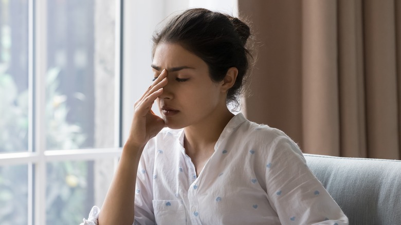 Woman looking stressed and touching face 