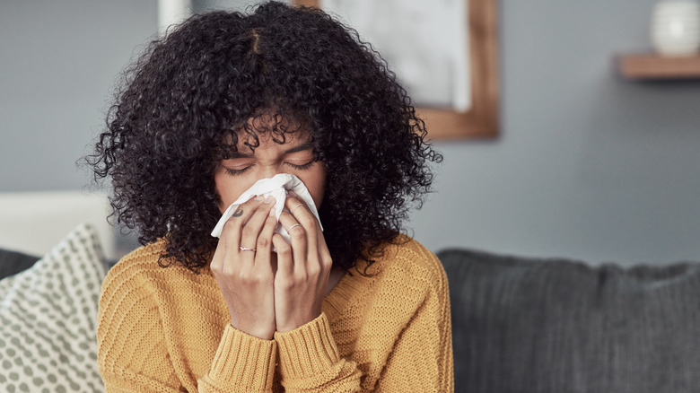 A woman sneezing