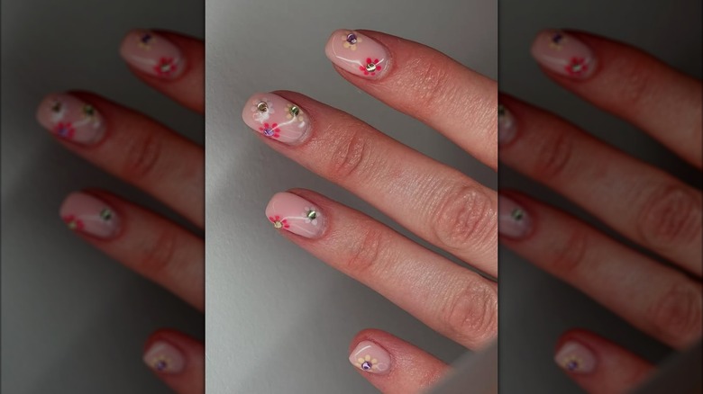 A hand with tiny flowers manicured on the nails