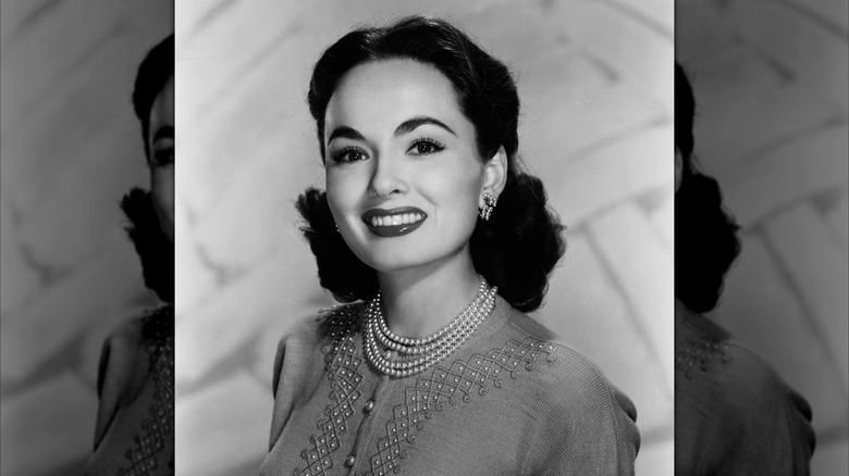 Ann Blyth in a cardigan with a pearl necklace in 1955