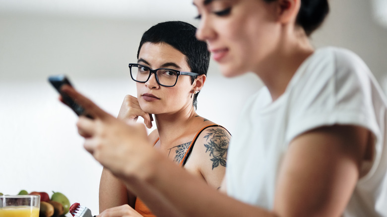 Woman texting, another woman looking at her