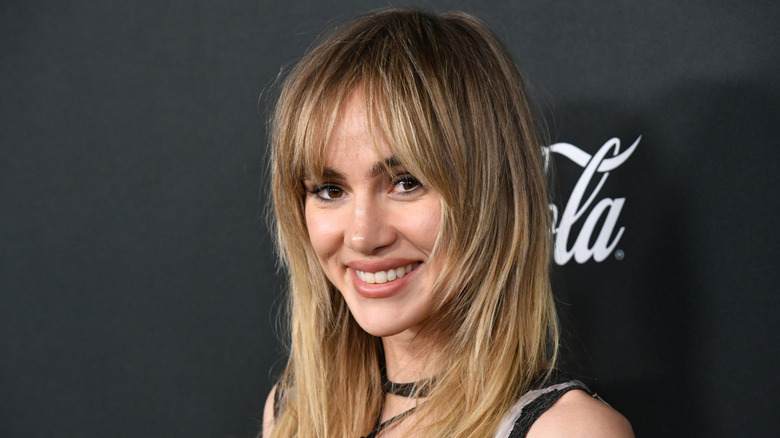 Suki Waterhouse smiling on a red carpet