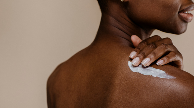 Woman applying body cream