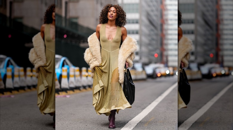 A woman in a dress with a fur coat