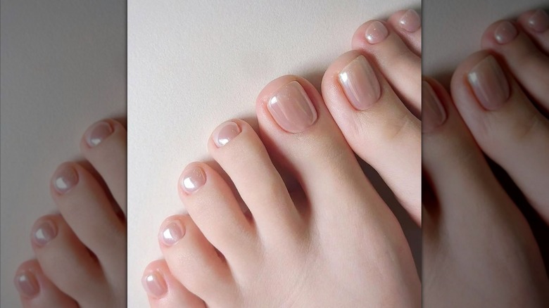 Close-up of toes with a shiny, chrome-finish pink nail polish