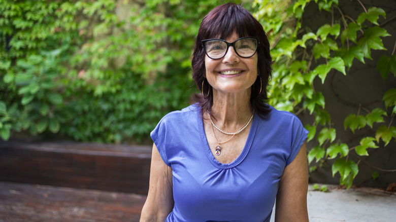 Older woman smiling with purple shirt