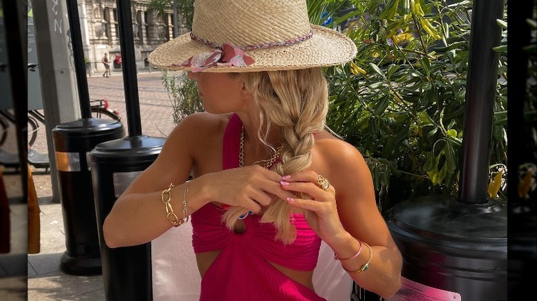 Woman braiding hair wearing bangles