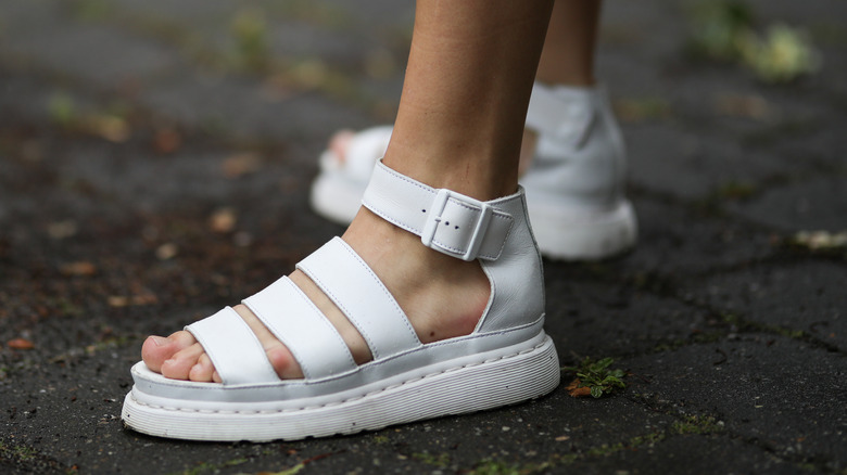 Woman wearing white strappy sandles 