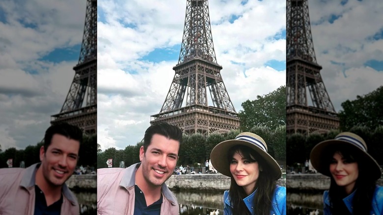 An outdoor selfie of Zooey Deschanel and Jonathan Scott smiling in front of the Eiffel Tower in Paris