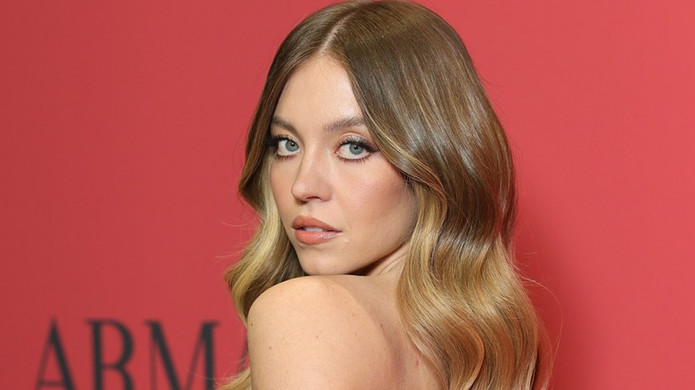 Sydney Sweeney posing over her shoulder on the red carpet