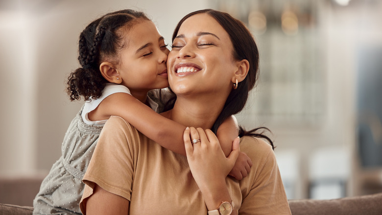 smiling mom and daughter hugging