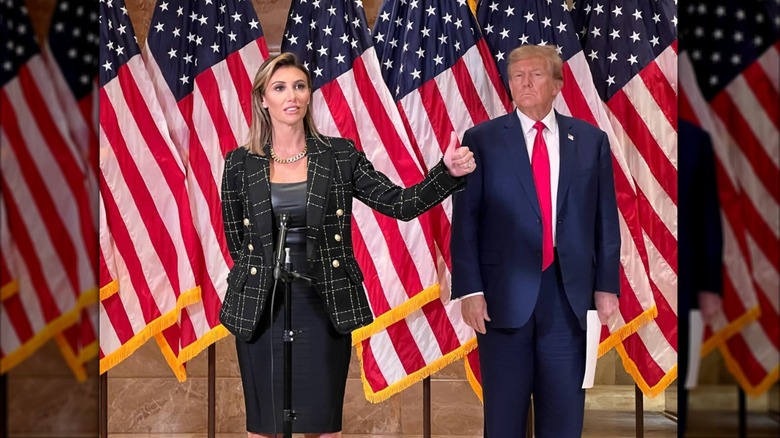 Alina Habba in a black and white outfit on stage with Donald Trump