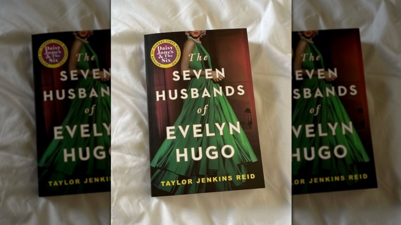 A copy of "The Seven Husbands of Evelyn Hugo" laying on a white sheet
