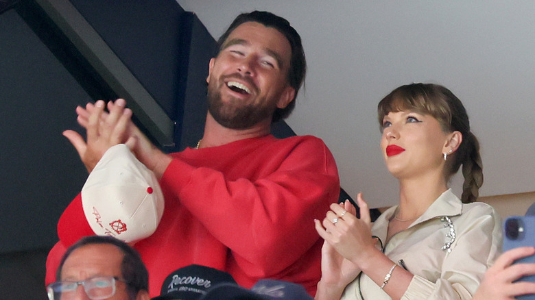Taylor Swift and Travis Kelce clapping at an event