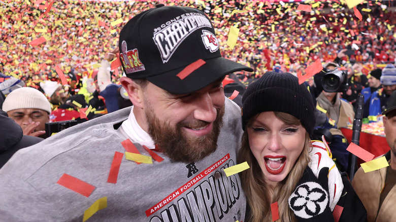 Taylor Swift and Travis Kelce on the football field after a Kansas City Chiefs win