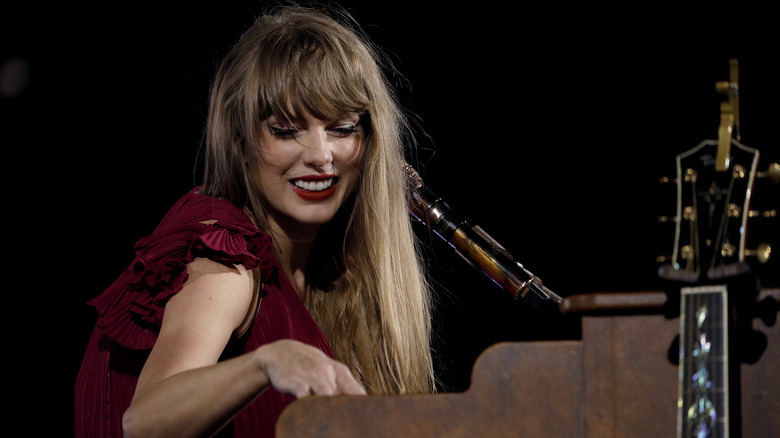 Taylor Swift smiling while playing piano