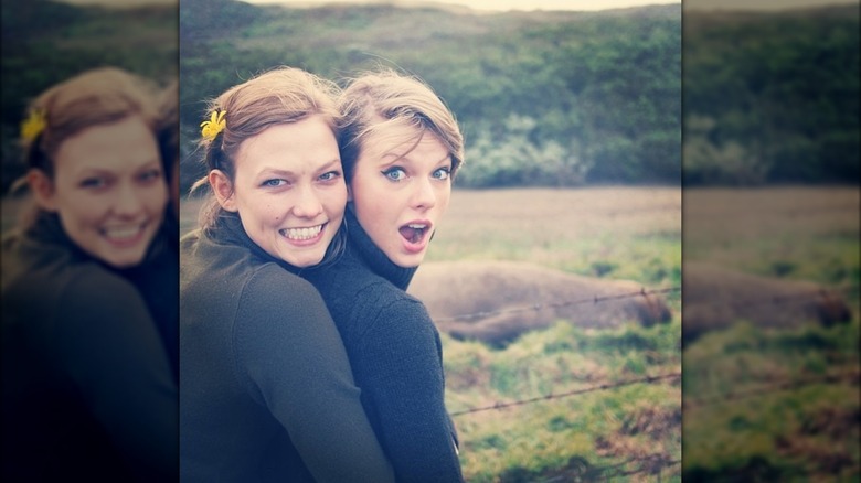 Karlie Kloss embracing Taylor Swift from behind while they pose for a photo