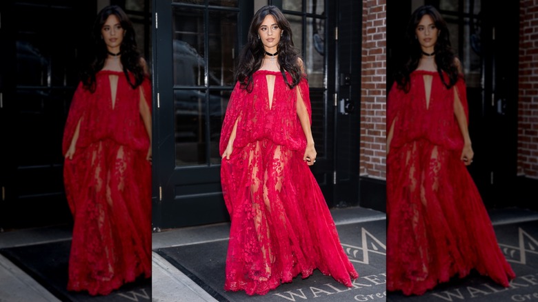 Camila Cabello walking in a flowing fuchsia dress of lace