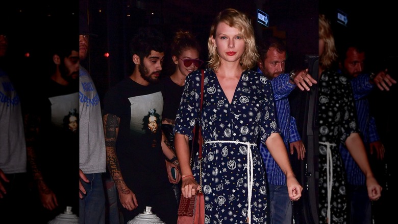 Taylor Swift walking in front of Zayn Mailk and Gigi Hadid while wearing minimal makeup