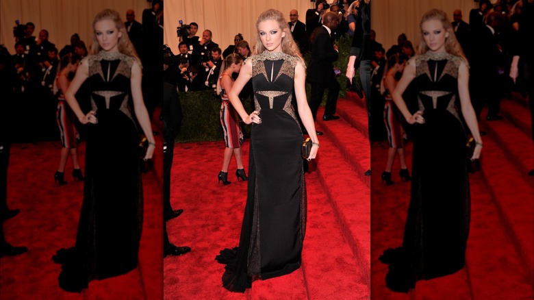 Taylor Swift on the red carpet in a black gown with lace cutouts