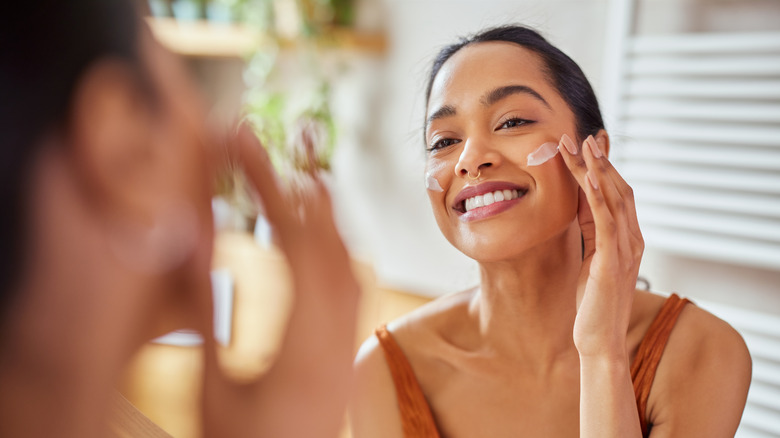 A woman applying skincare 
