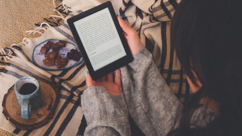 Woman reading Kindle with coffee and snacks