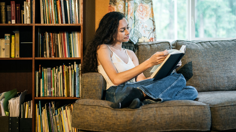 A woman enjoys reading a book in the comfort of her own home