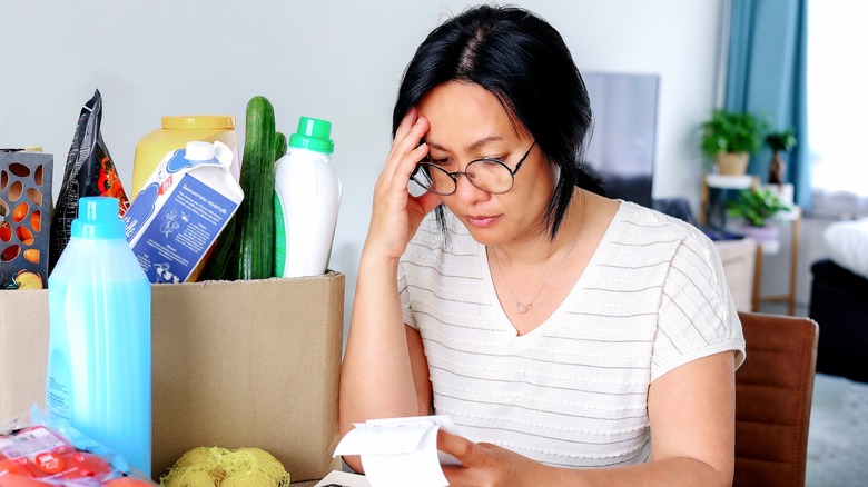 Stressed woman holding receipts