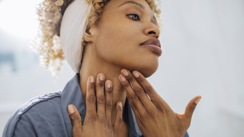 Woman touching neck