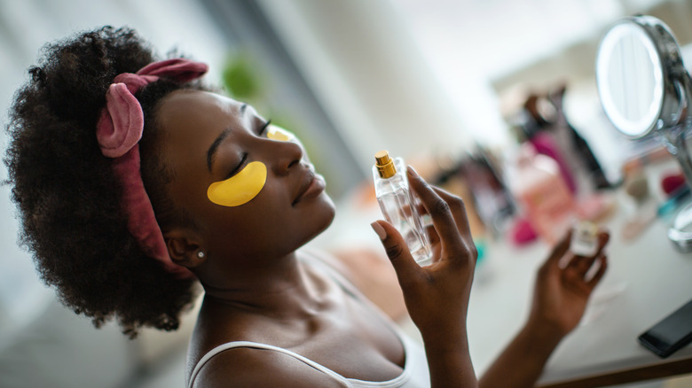 woman putting on fragrance