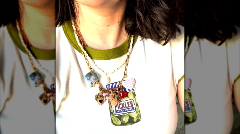 A woman wearing a custom charm necklace with a pickle shirt