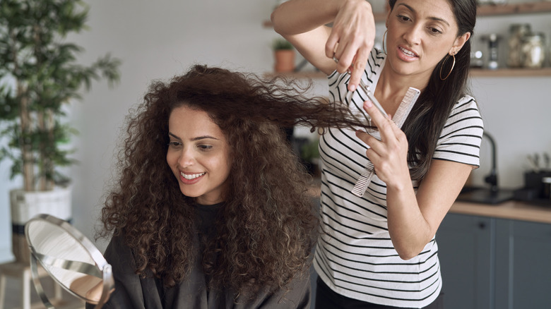 Curly-haired woman getting haircut