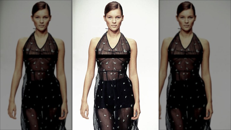 Kate Moss walks the catwalk wearing a sheer black dress
