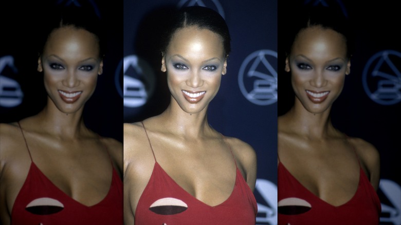 Tyra Banks smiles wearing black eyeliner and white eye shadow