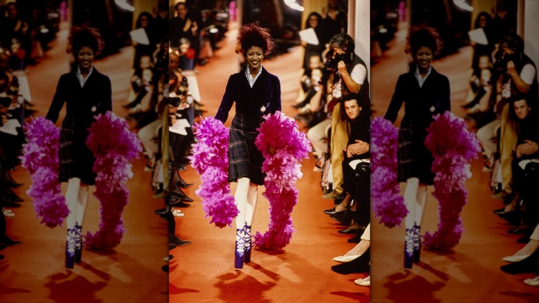 Naomi Campbell runs down the catwalk carrying a pink feather boa